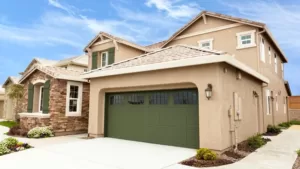 View Of Garage And House With Beige Stucco On The Exterior