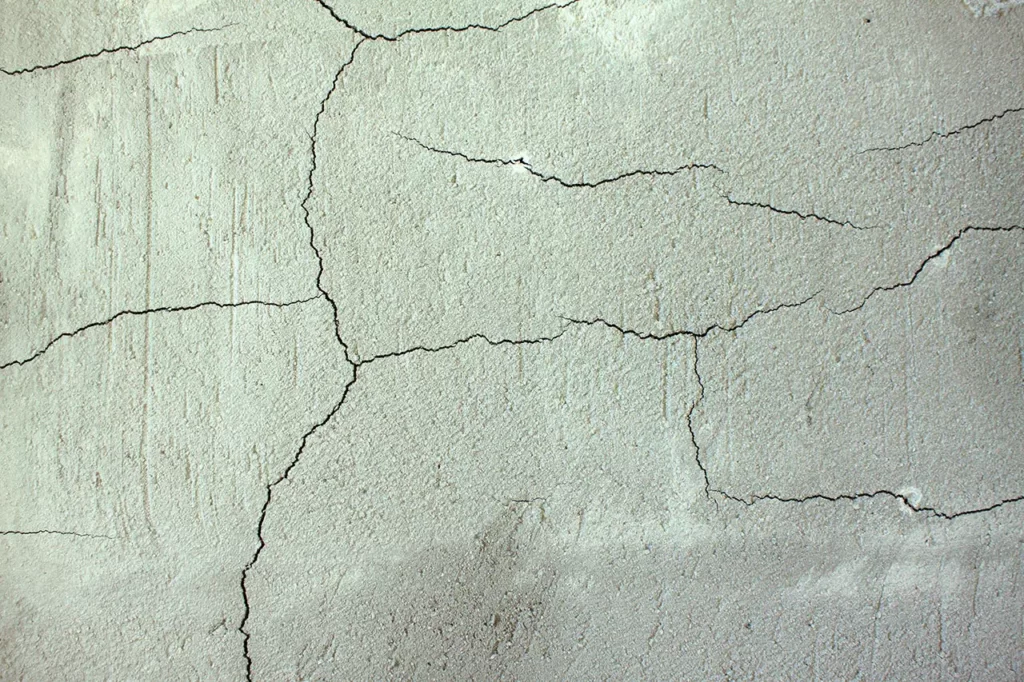 Hairline spider cracks in concrete wall
